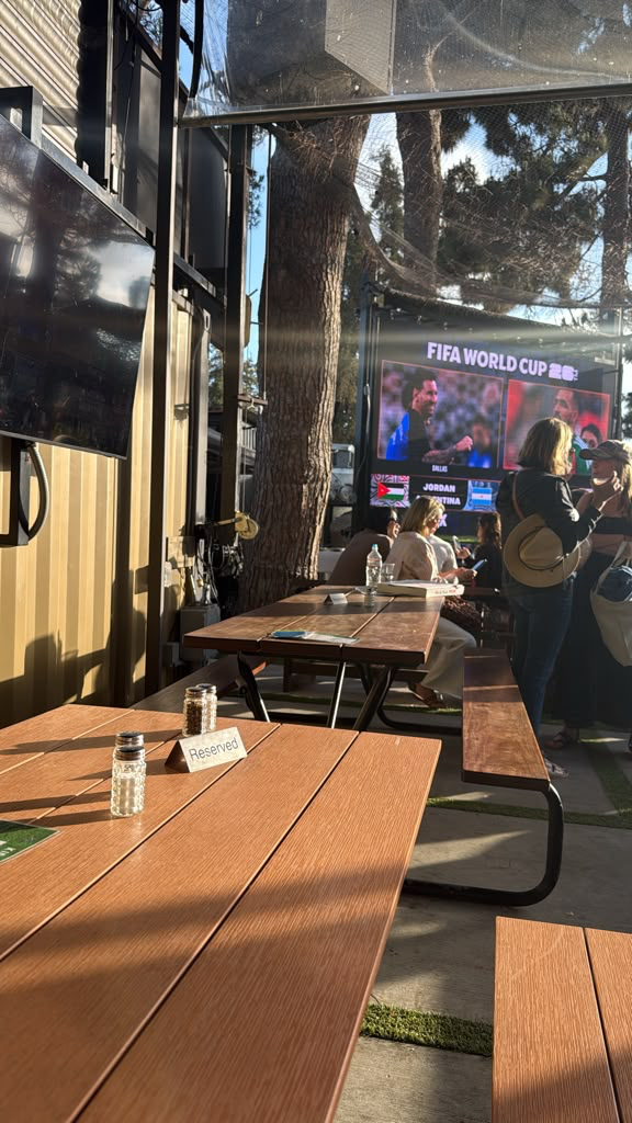 Outdoor patio with a big screen showing a World Cup match